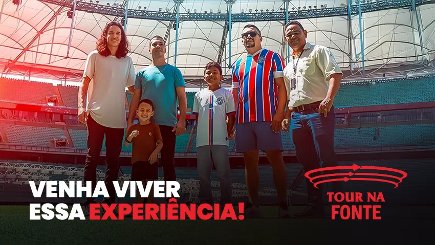 Família posa no gramado da Arena Fonte Nova durante o Tour na Fonte, com a mensagem ‘Venha viver essa experiência’